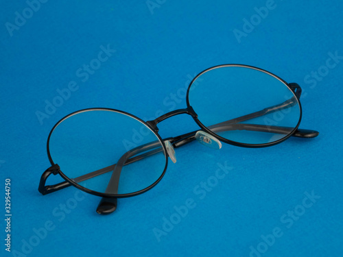 black folded glasses lie on a blue background