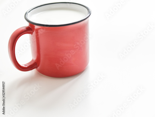red mug with milk on a white background