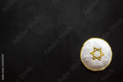 Jewish Kippah Yarmulkes hats with Star of David on black table. Religion Judaisim symbol. Top view, space for text photo