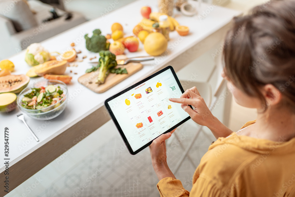 Woman shopping food online using a digital tablet at the kitchen. Concept  of buying online using mobile devices Photos | Adobe Stock