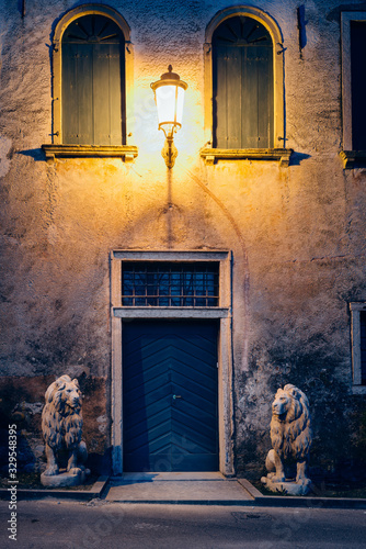 Bassano del Grappa, Vicenza Italy - February 28, 2020: Entrance door with statues depicting two lions of villa Ca' Erizzo Luca at evening photo