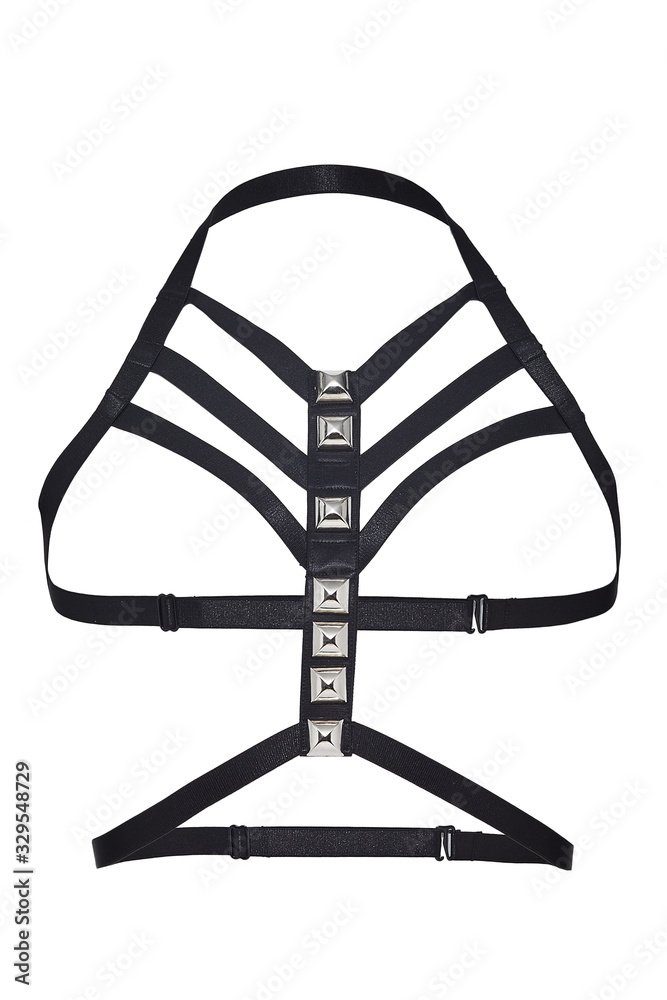 Subject shot of a black harness made of multirow satin straps decorated with steel rivets and fitted with slider adjusters and hook fasteners. The harness is isolated on the white background. Subject shot of a black harness made of multirow satin straps decorated with steel rivets and fitted with slider adjusters and hook fasteners. The harness is isolated on the white background.