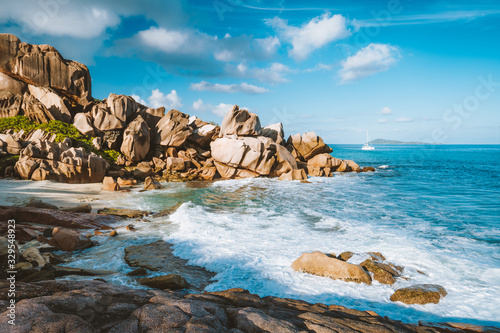 Fototapeta Naklejka Na Ścianę i Meble -  Grand L Anse, La Digue, Seychelles. Tropical coastline with hidden beach, unique granite rocks and lonely sail boat in ocean