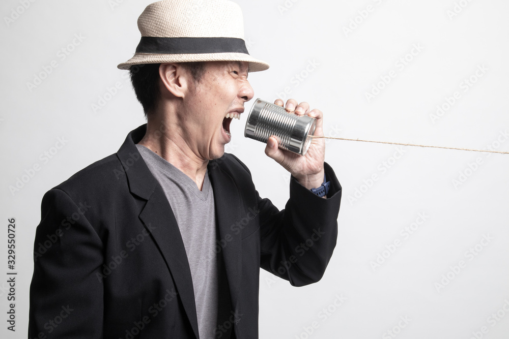 Angry Adult Asian man shout with tin can phone. Angry Adult Asian man shout with tin can phone.
