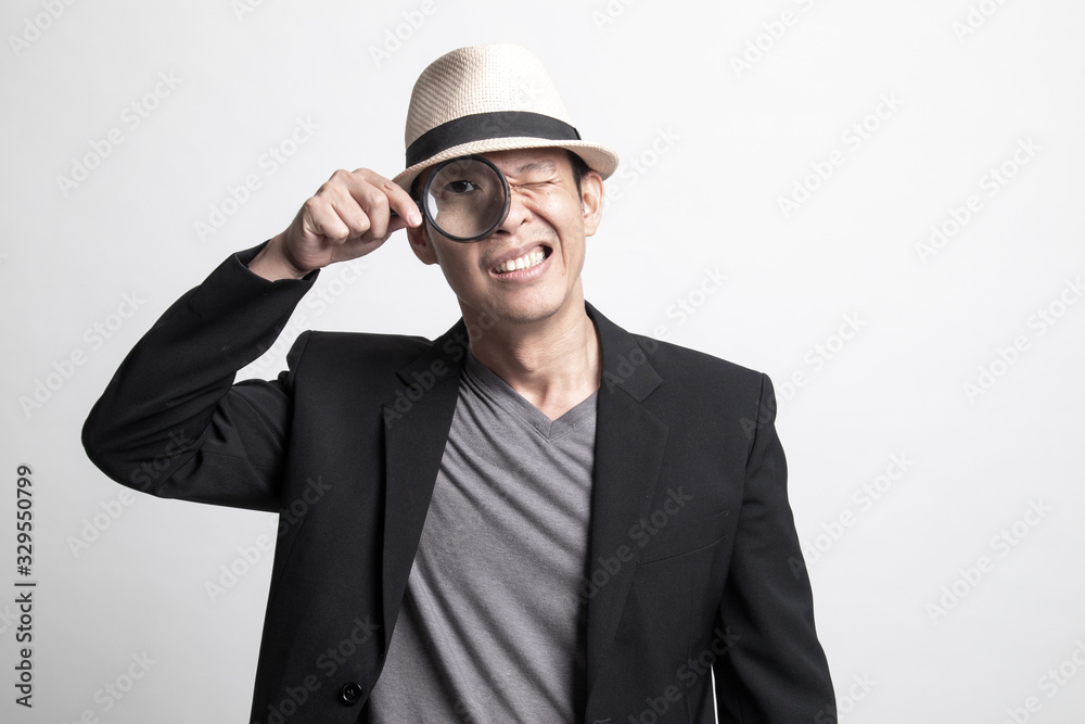Young Adult Asian man with a magnifying glass. Young Adult Asian man with a magnifying glass.