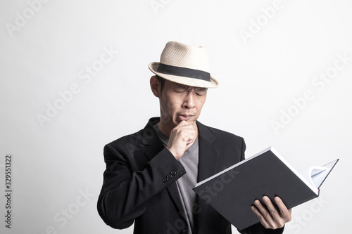 Adult Asian man  with a book is thinking.