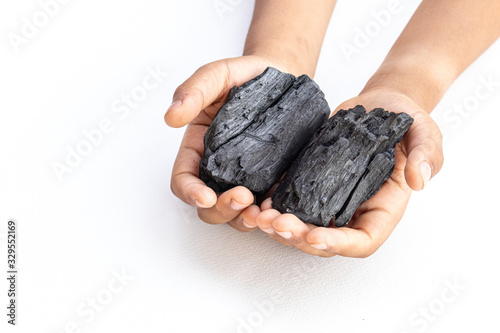 Asia child hand holding black charcoal on white background.
