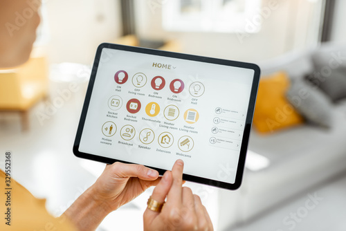 Controlling smart home devices using a digital tablet with launched application. Smart home concept