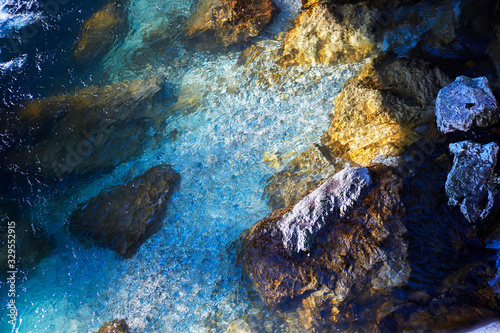 Turquoise crystal clear fresh water of the Alpine mountain river stream with rocky shore