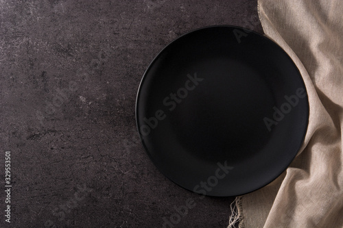 Empty black plate on black background top view
