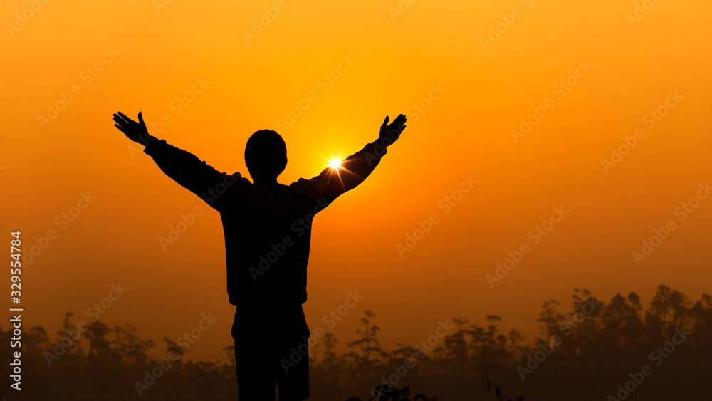 Human lift two hands up and praying to God on sky with light sunset background, christian silhouette concept.
