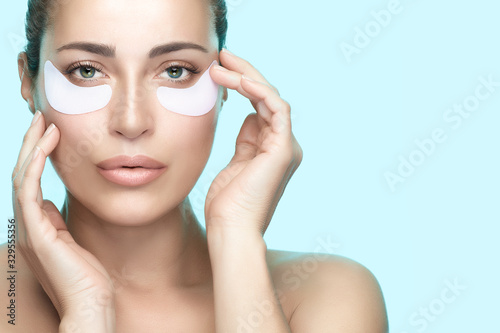 Foto Beauty woman face with perfect clean skin using eye patches