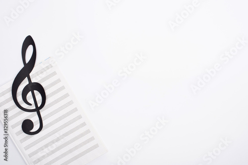 Top view of black paper cut note with music book on white background