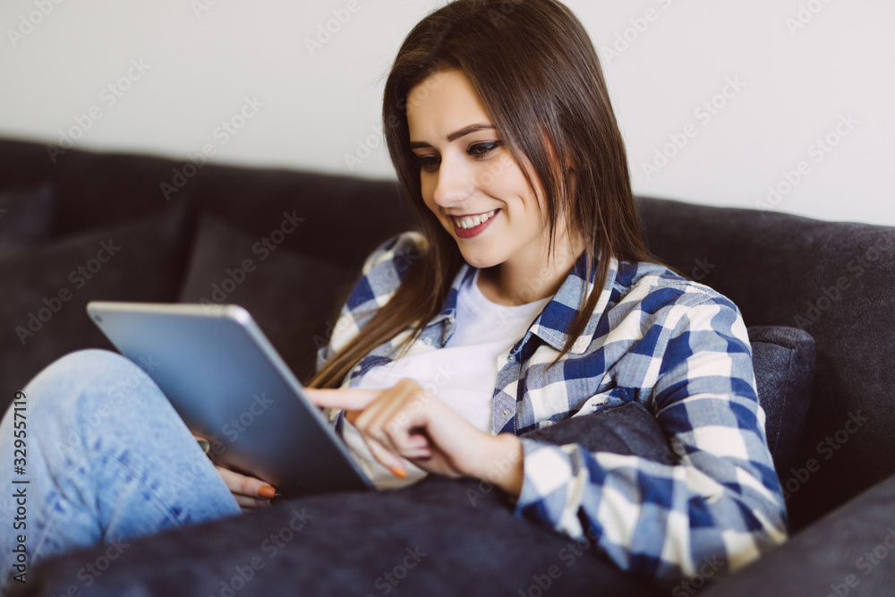 Young beautiful woman with tablet on sofa at home Young beautiful woman with tablet on sofa at home