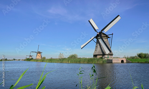 Holland windmills on the riverside under the blue sky; spring scenery