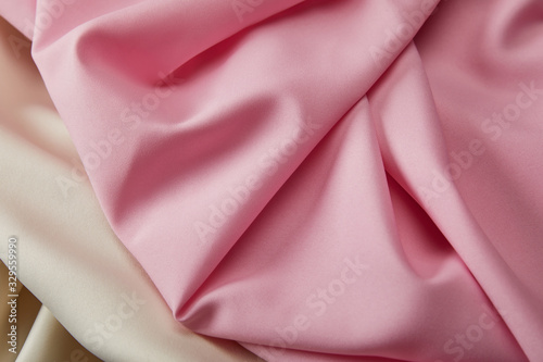close up view of satin pink and white soft and wavy fabric