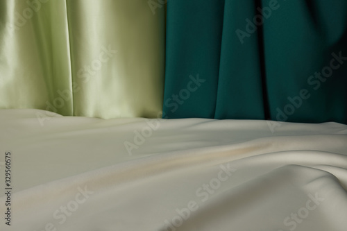 close up view of emerald  light green and white soft and wavy silk fabric