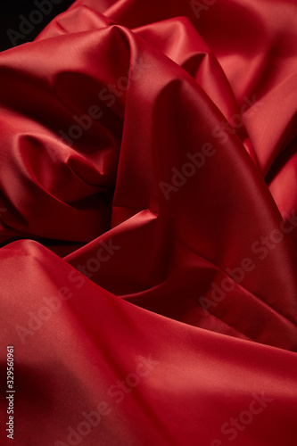 close up view of red soft and crumpled silk textured cloth isolated on black