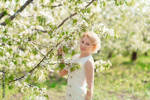 blonde girl with branch of flowering tree © andrey