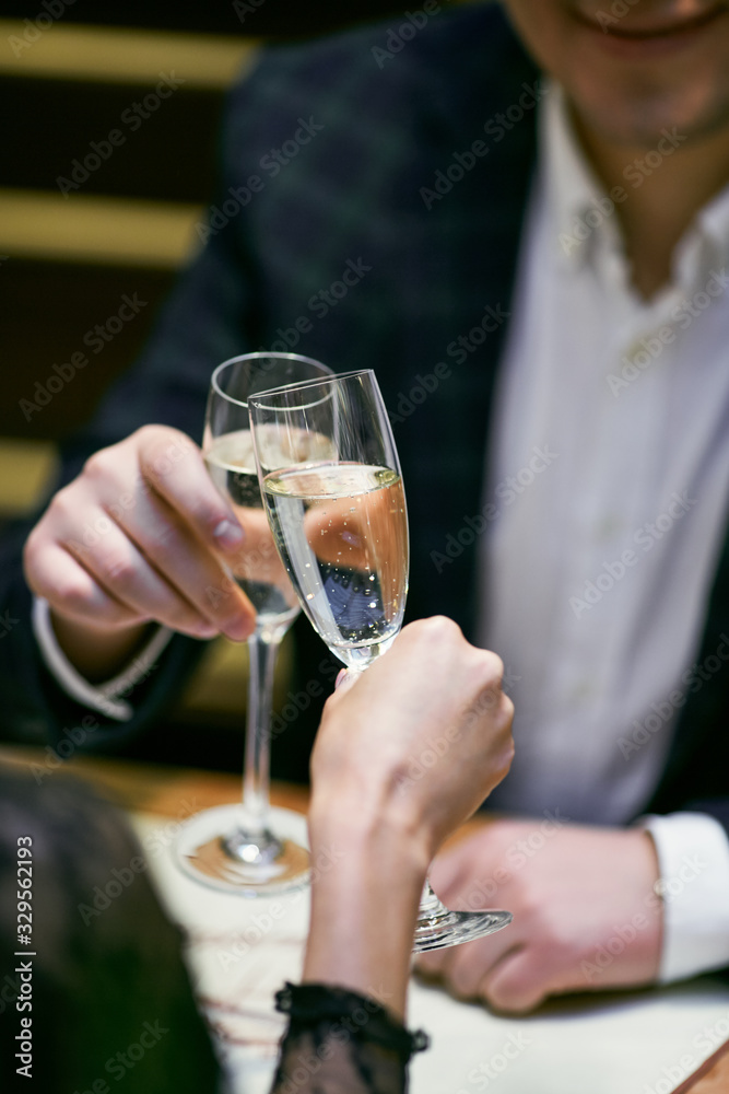 Beautiful young couple with glasses of Champaign in luxury restaurant. Couple have romantic evening in restaurant. 