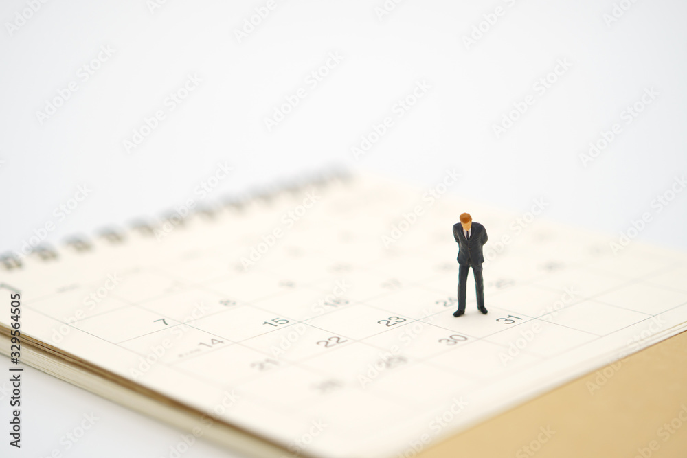 Miniature people businessmen standing on white calendar using as background business concept and finance concept with copy space for your text or design. Miniature people businessmen standing on white calendar using as background business concept and finance concept with copy space for your text or design.