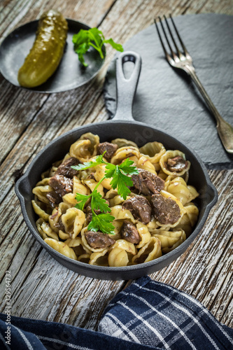 Italian pasta shells with beef sauce in cast iron pan.