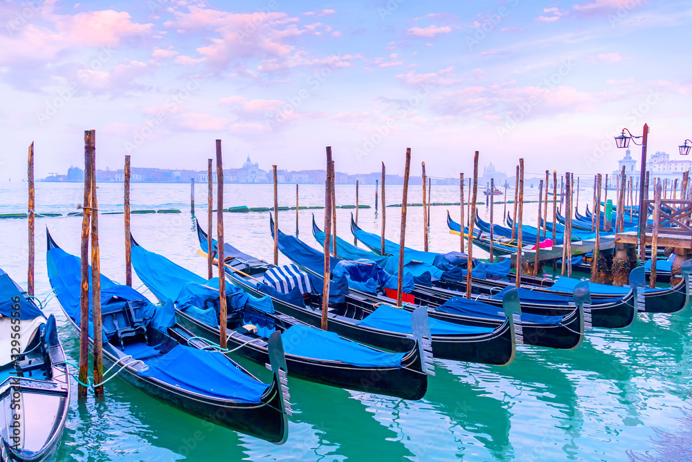 Venetian gondolas in lagoon of Venice at sunset, Italy