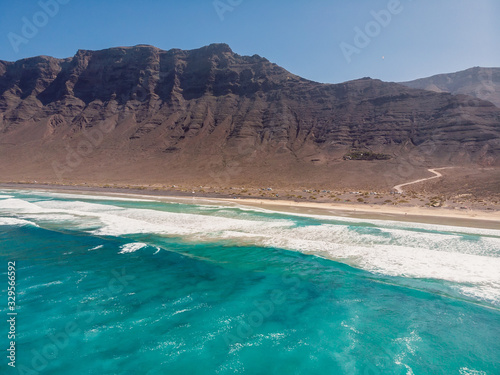 Aerial view of Famara beach with ocean and mountains in Lanzarote, Spain