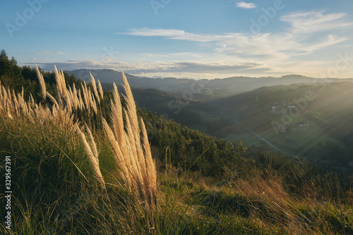 Sunny landscape at sunset with mountains behind Sun rays Errigoiti Basque Country