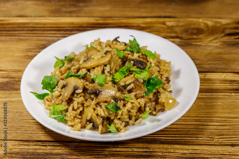 Tasty risotto with mushrooms on wooden table