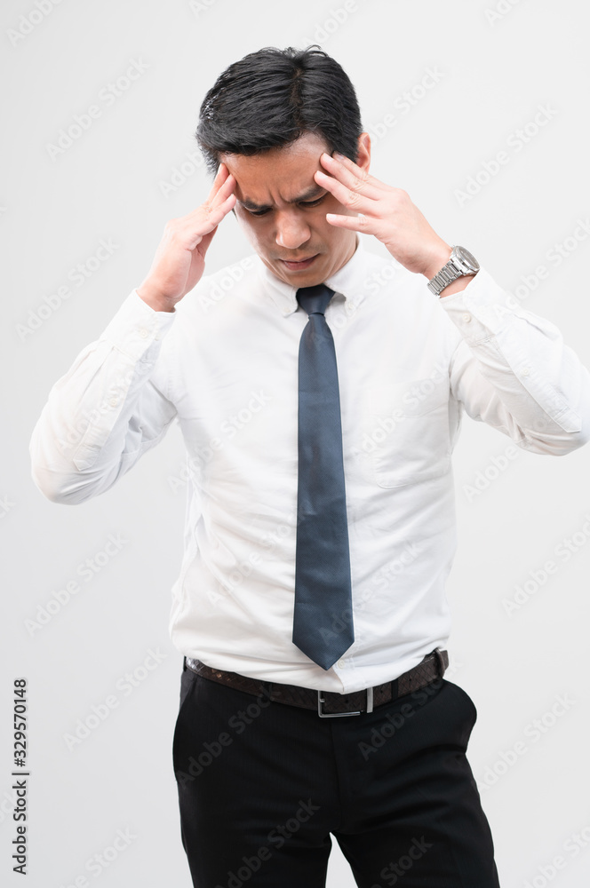 Exhausted Asian worker man squeezing his head to try relaxing from hard work shows pain expression face, concept working exhausted, office worker lifestyle, office syndrome, tiring work hour. Exhausted Asian worker man squeezing his head to try relaxing from hard work shows pain expression face, concept working exhausted, office worker lifestyle, office syndrome, tiring work hour.