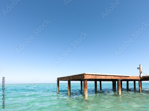 Blue sky and sea, ocean. A fabulous paradise. Jetty pier on the ocean. Wooden beams in the water. Blue horizon Rest or travel to the sea. © Svetlana
