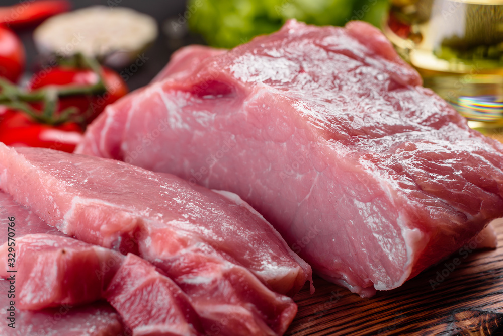 Fresh pieces pork ready to cook on a dark background in the kitchen