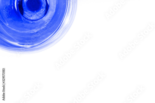 Glass with art blue water on white background. Color of the year concept. Top view, flat lay, copy space. isolated.