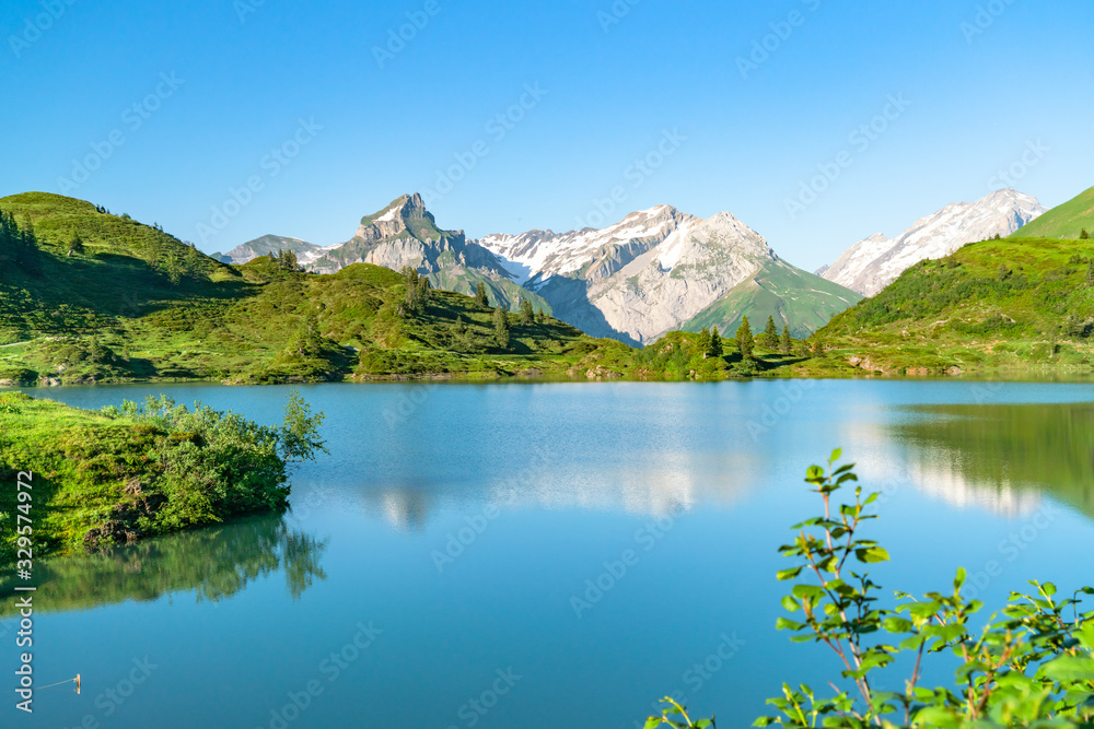 Panorama of beautiful snow mountains and lake on a sunny summer day; natural scenery