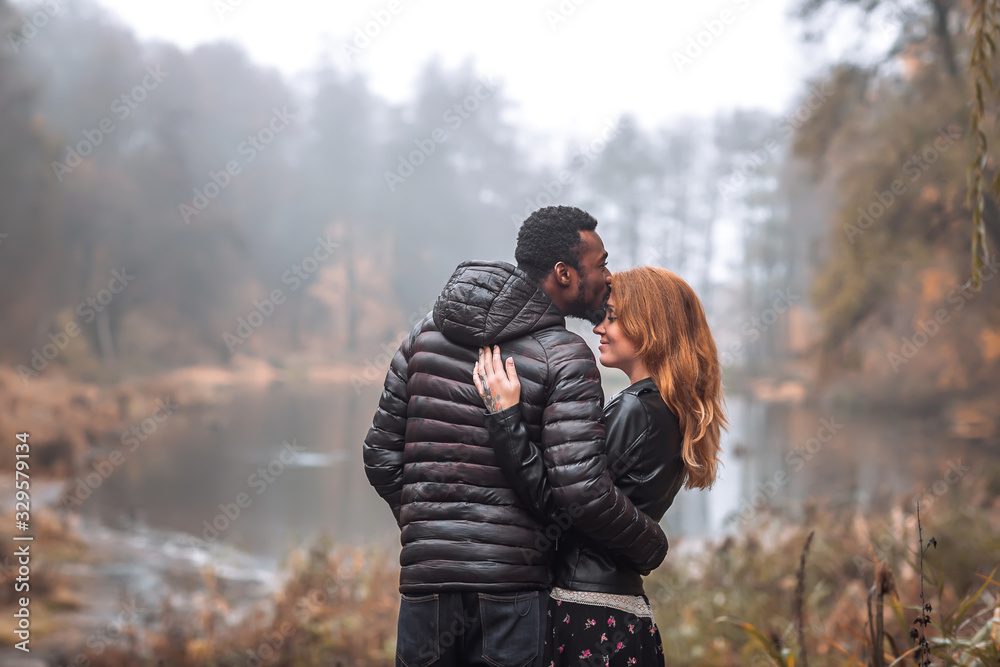 Interracial couple posing in autumn leaves background Interracial couple posing in autumn leaves background