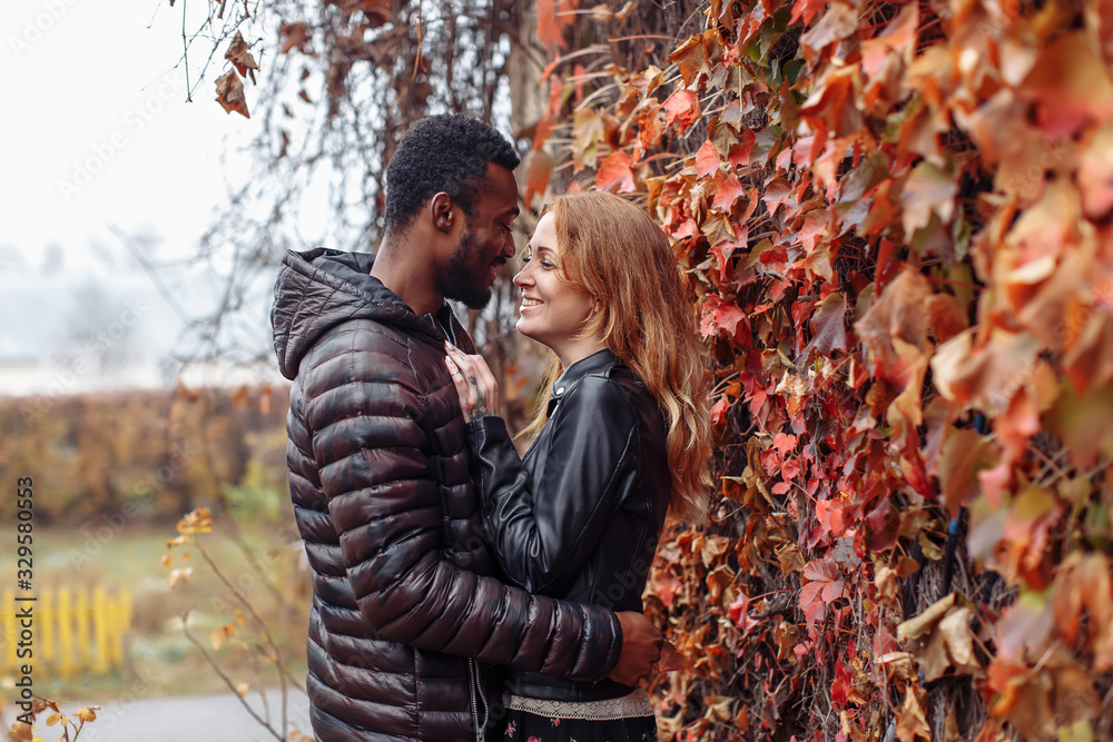 Interracial couple posing in autumn leaves background Interracial couple posing in autumn leaves background