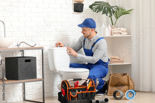 Handsome plumber repairing ...