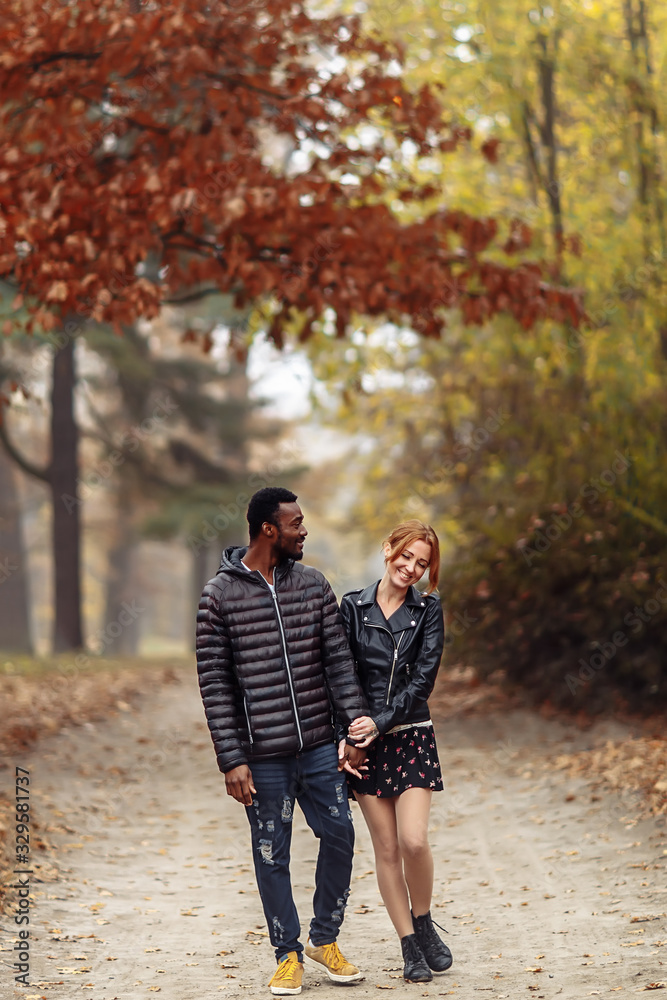 Happy interracial couple walking in autumn park Happy interracial couple walking in autumn park