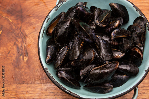 Raw mussels in a blue colander