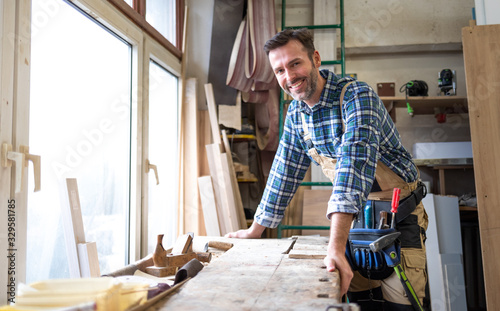 Portrait of middle aged carpenter in the carpentry workshop photo