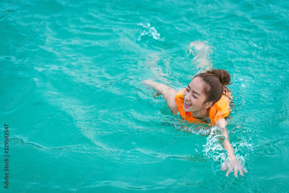 in relaxing time with girl play sea by wearing Life jacket