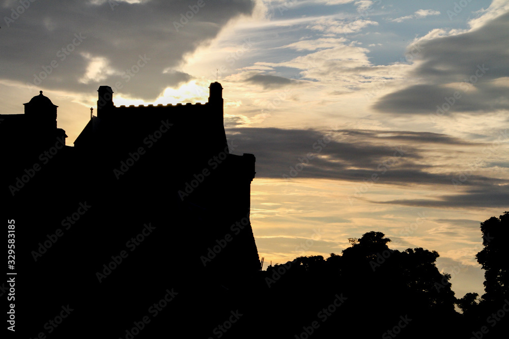 colored cloudy sky at valavon with the silhouette of a fortified castle and a forest colored cloudy sky at valavon with the silhouette of a fortified castle and a forest