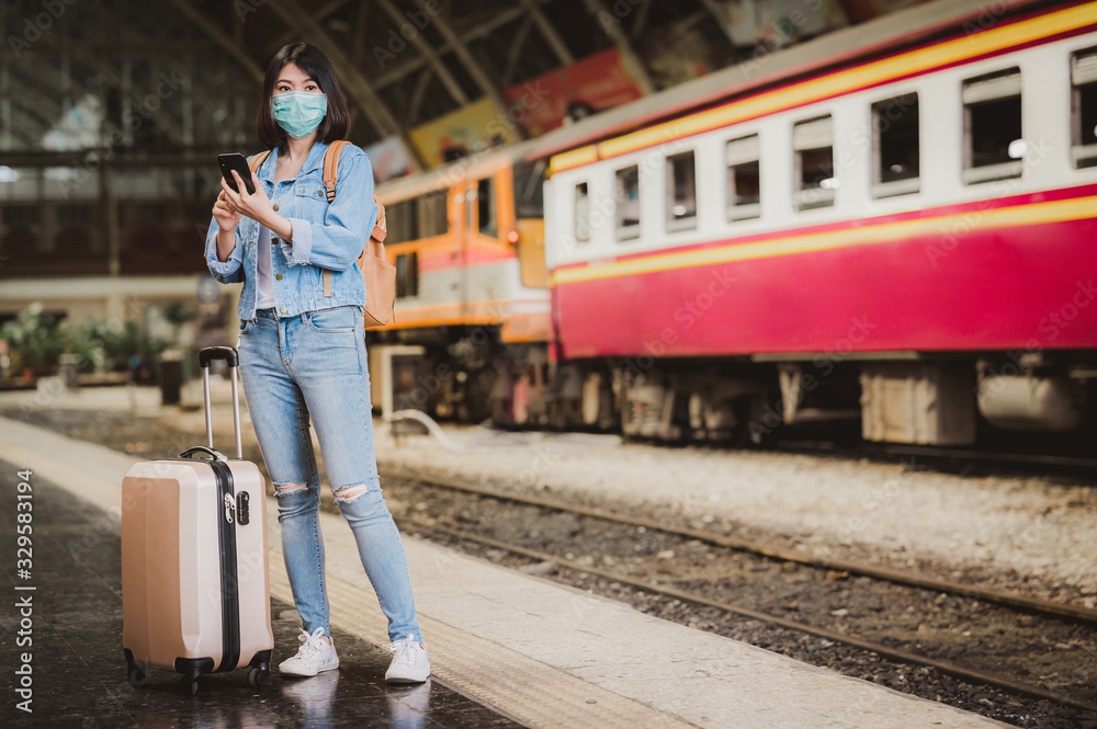 woman tourist at train station wearing face mask