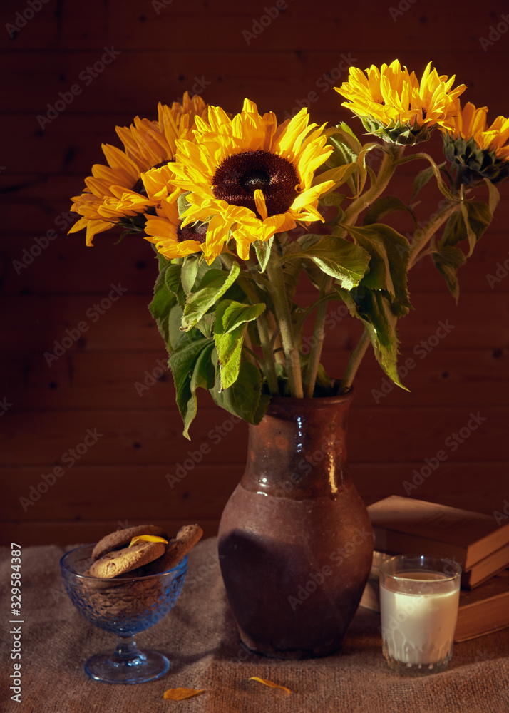 Bouquet of sunflowers in a clay jug on the table on the wooden background. Bouquet of sunflowers in a clay jug on the table on the wooden background.