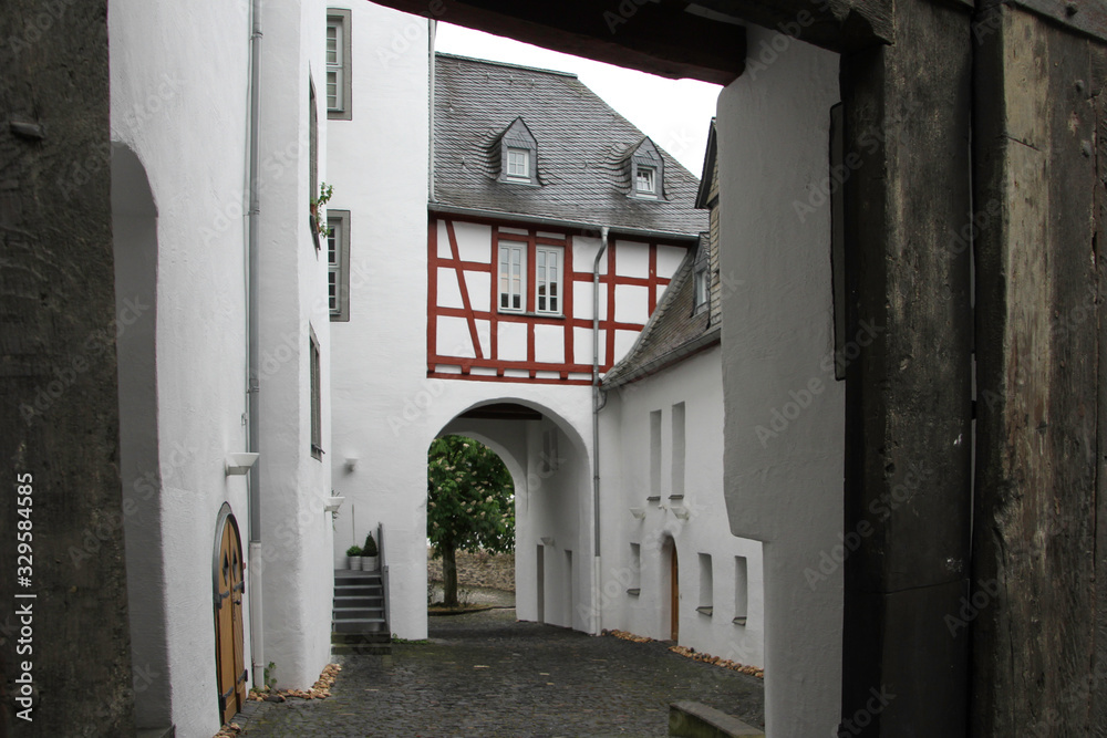 old passage to a courtyard in the old town with behind a garden with tree
