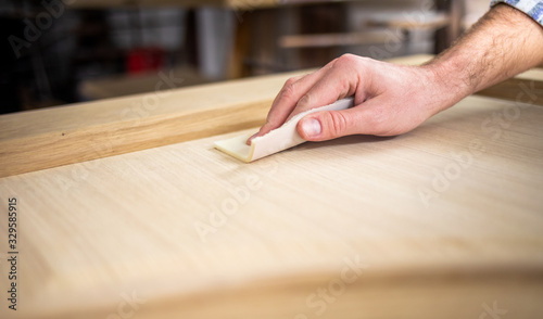 Close up of abrasive paper polishing a wooden board photo