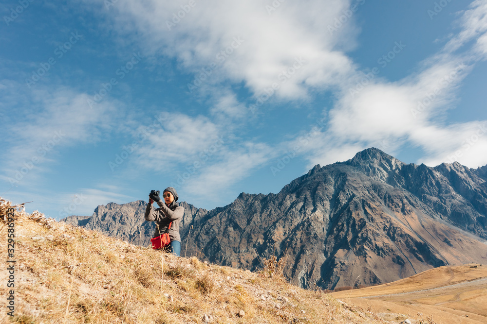 Woman tourist is taking a photo of mountain landscape.