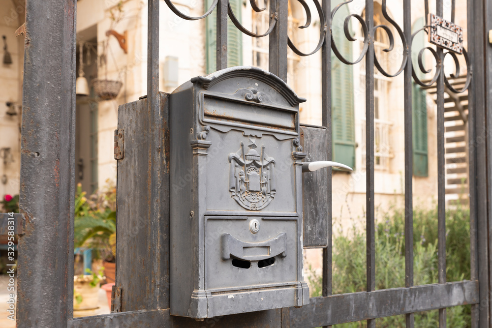 A metal mailbox with the emblem of the Jerusalem Post hangs on a metal fence in the old district of Jerusalem city in Israel