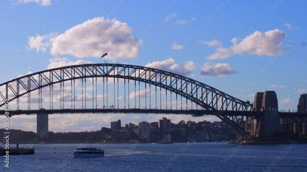 Time Lapse of Sydney Harbour on a Summer afternoon at Sunset blue skies with orange white clouds and boats in the harbour Time Lapse of Sydney Harbour on a Summer afternoon at Sunset blue skies with orange white clouds and boats in the harbour